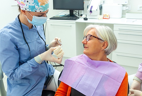 a dentist and patient chatting about implant dentures