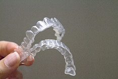A person holding a top and bottom Invisalign aligner in their hand in McMinnville